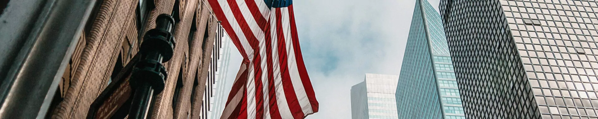 Bandiera americana che sventola con grattacieli sullo sfondo